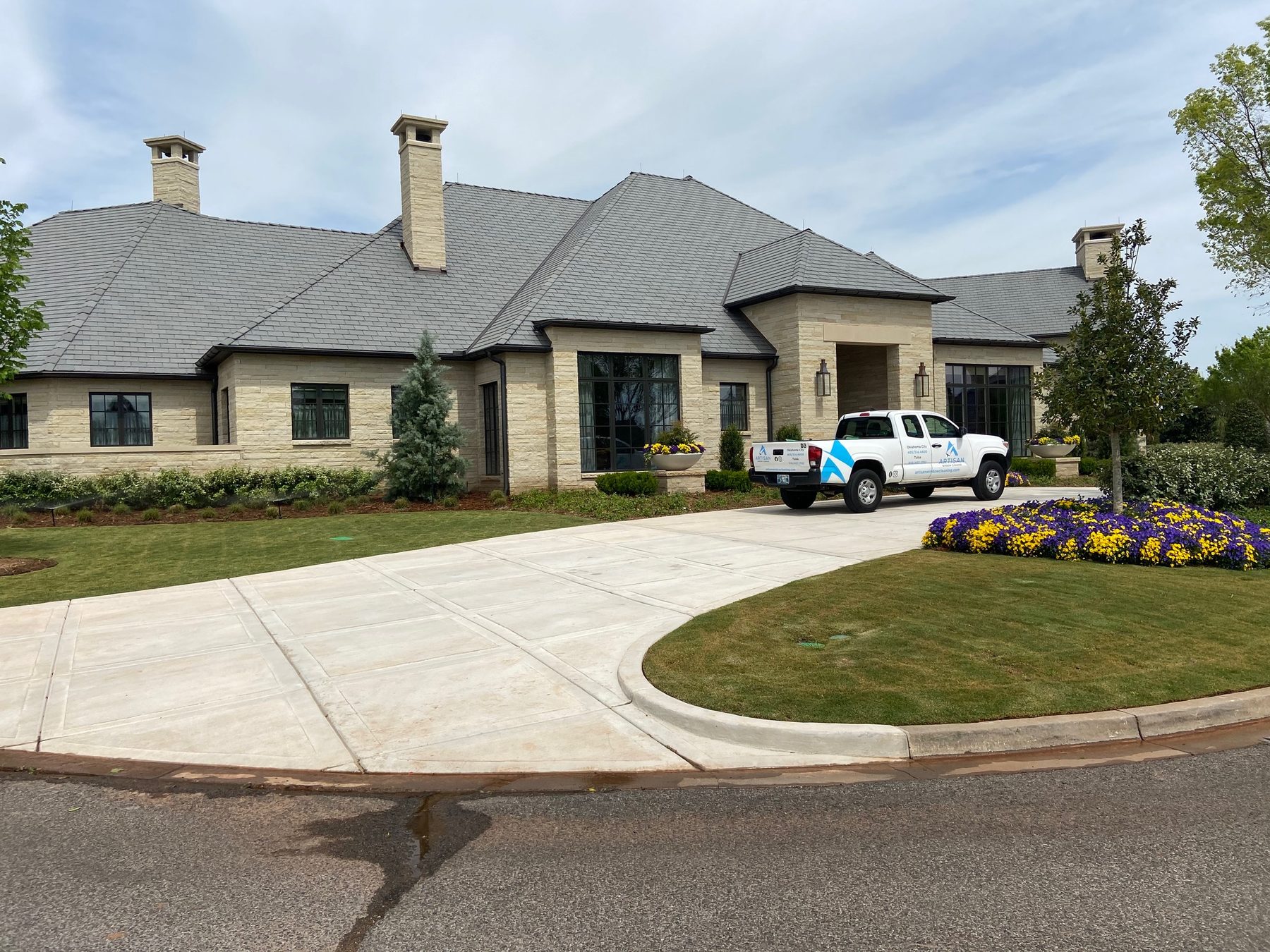 Artisan truck at a large stone home after a window cleaning